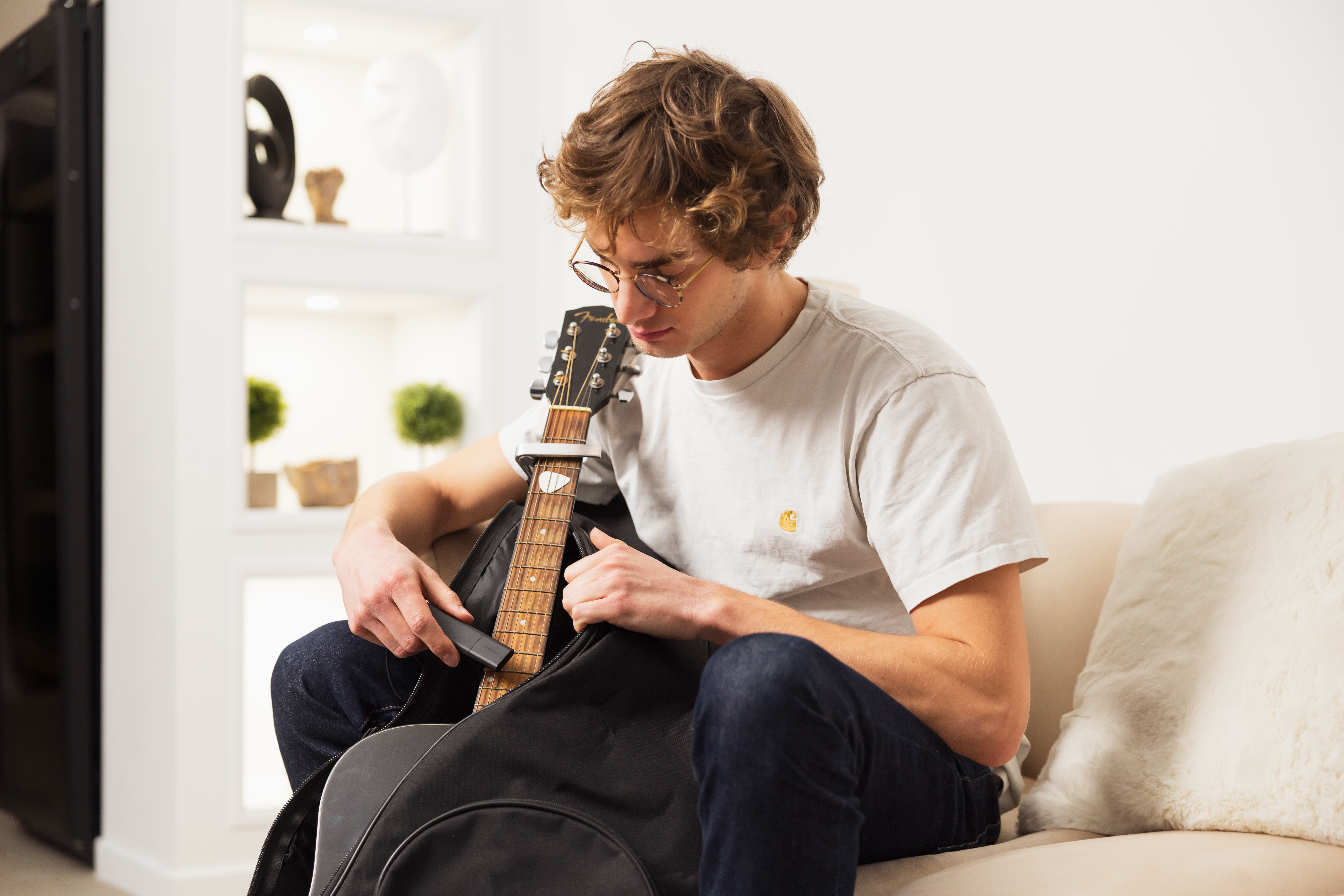 A young man hides a Classic GPS Tracker in a guitar case